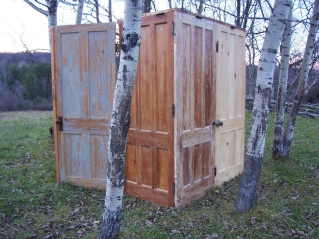 Armoire with double door entry, made with seven vintage doors, twenty two vintage hinges, copper rod, six doorknobs, and one doorbell. 79"h x 70"w x 33"deep.